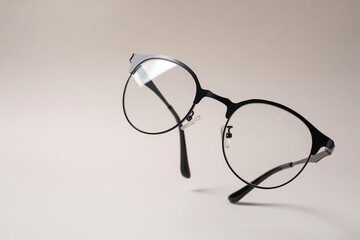 Stylish pair of glasses with black frame on beige background. Space for text