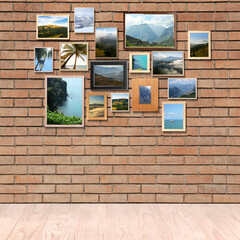 Many beautiful landscapes in frames on brick wall in room