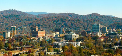 Aerial view of Asheville city in North Carolina with high buildings and mountain hills in distance