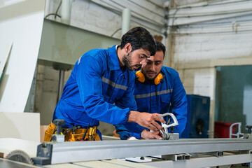 Modern industrial machine operator working in industrial factory. Woodworking carpenter furniture...