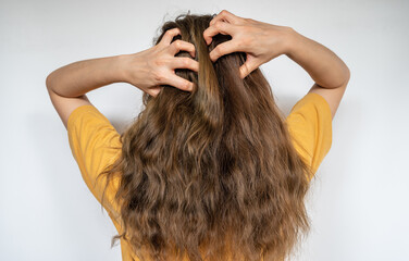 Obraz premium Rear view of young woman while scratching her scalp caused of itchy scalp.