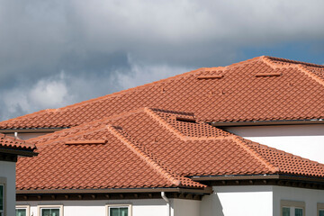 House rooftop covered with yellow ceramic shingles. Tiled covering of residential apartment building