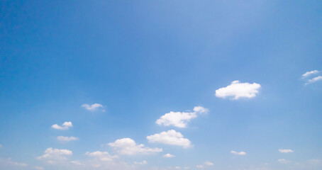 Panoramic view of clear blue sky and clouds, Blue sky background with tiny clouds. White fluffy clouds in the blue sky. Captivating stock photo featuring the mesmerizing beauty of the sky and clouds.