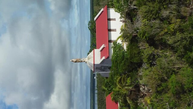 Aerial view rising over the Chapelle Notre Dame de Lourdes, in Lifou, New Caledonia. vertical orientation