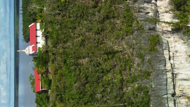 Aerial view of a hilltop Chapel, in Lifou, New Caledonia - circling, drone shot. Vertical format