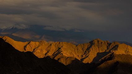 View of high-altitude mountains in Ladakh with sun rays and shadows falling on them. 