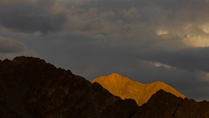 View of high-altitude mountains in Ladakh with sun rays and shadows falling on them. 
