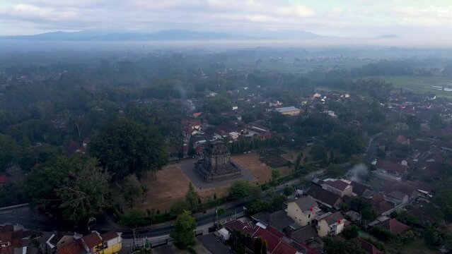 Mendut temple surrounded by small township in Central Java, Indonesia, aerial view