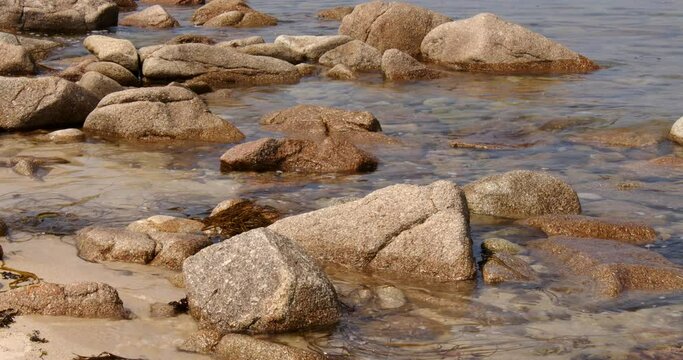 a series of eroded rocks and the sea lapping around then on the beach on St Agnes at the Isles of Scilly 6 of 6