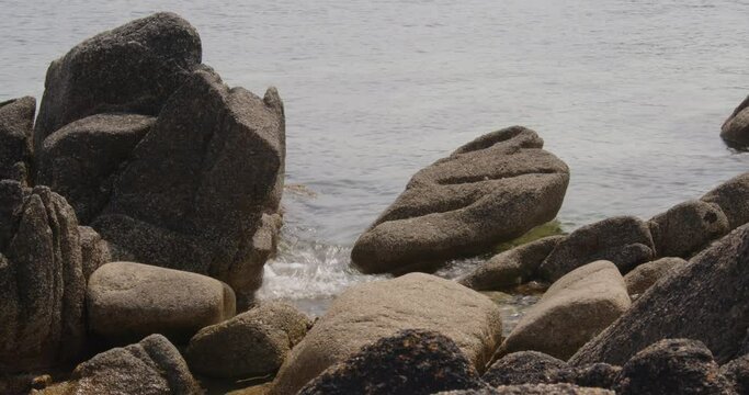 a series of eroded rocks and the sea lapping around then on the beach on St Agnes at the Isles of Scilly 5 of 6