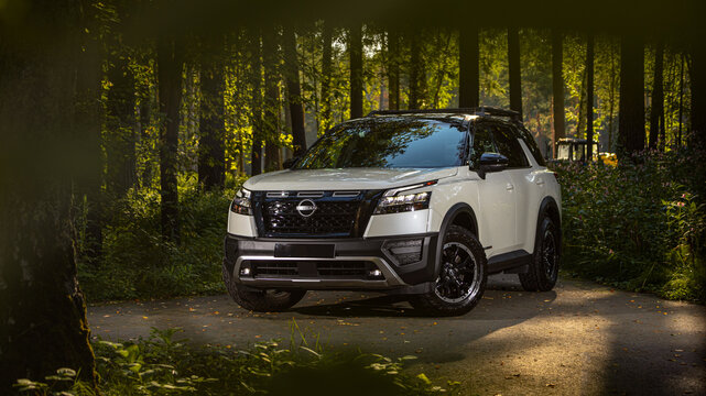 Novosibirsk, Russia - August 23 , 2023: white Nissan Pathfinder Rock Creek   SUV parked in the forest, front view
