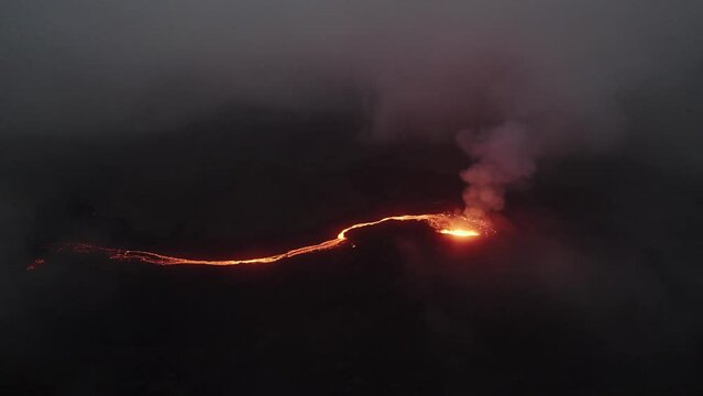 counter clockwise drone shot of the litli hrutur volcano in iceland with fog and smoke