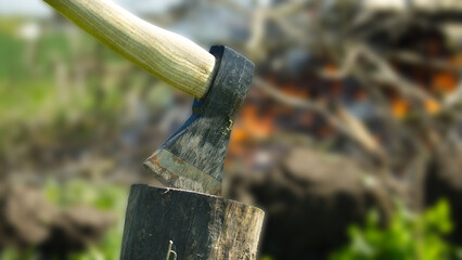 Axe with a black blade stuck in the log