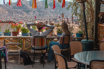 Pareja de turistas disfrutando de la vista de Cusco, Perú en una terraza de un restaurante