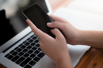 Close up one person business man hands typing texting phone gadget with laptop on table working studying indoor online with black screen with phone computing electronic devices using internet network