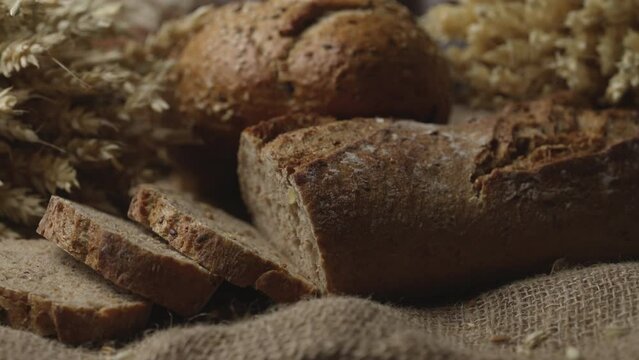 Rustic bread and ears of wheat on the old vintage table. Baked natural bread. 4K ProRes