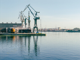Fototapeta premium Cranes in Gdansk Shipyard Aerial View. Motlawa River Industrial Part of the City Gdansk, Pomerania, Poland. Europe.