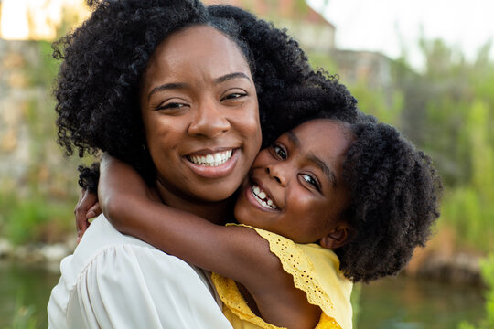 Happy mother and her beautiful daughter smiling.