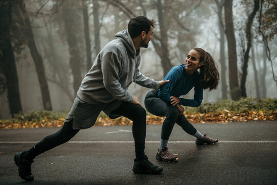 Two runners stretching their legs and warming up before the morning jog.