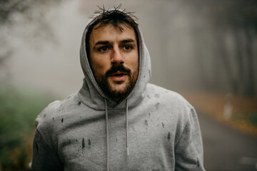 Close-up of a runner's determined expression as the pushes through the fog, determination clear in his eyes.