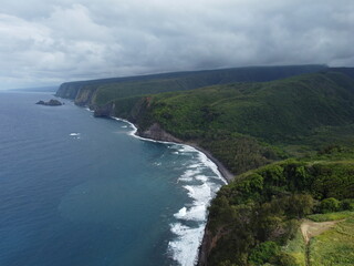 Aerial view of the coast line in Hawaii with the ocean and mountains at distance