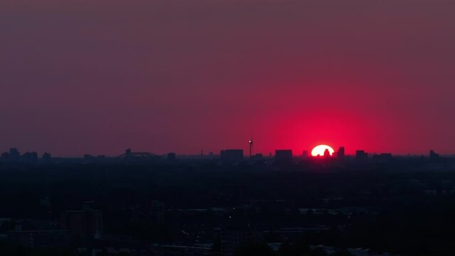 Sun is just rising behind the silhouettes of a city. Red sunrise background