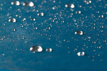 Micro close up of water drops with copy space on blue background