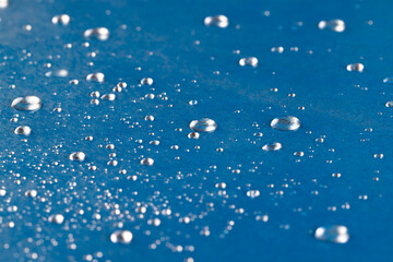 Micro close up of water drops with copy space on blue background
