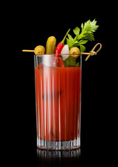 Cocktail mix with vodka and tomato juice bloody mary with celery,olive,pickle and onion on black background.