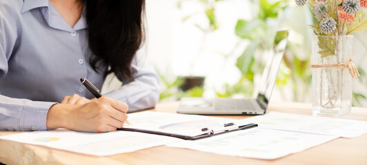 Asian businesswoman calculate financial graphs showing results about their investments, planning...