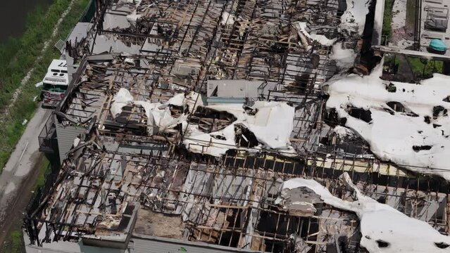 Above Drone wide shot of Roof of damaged apartment after burned by fire and firetruck 