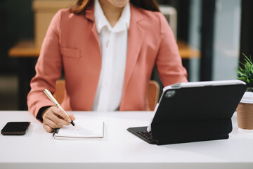 businesswoman hand working with new modern computer and writing on the notepad strategy diagram as concept morning light..