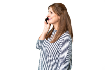 Middle age woman over isolated background keeping a conversation with the mobile phone with someone