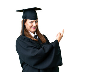 Middle age university graduate woman over isolated background pointing back