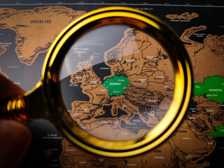 Hand holding vintage magnifying glass and focus to GERMAN map