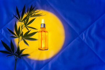 Cbd oil, soothing tincture, hemp branch, capsules on blanket in night bedroom