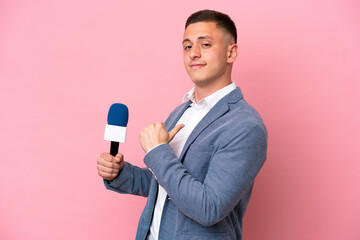 Young brazilian presenter man isolated on pink background proud and self-satisfied