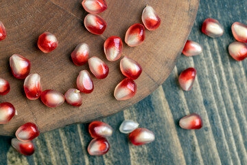 Red pomegranate seeds on the table and the board