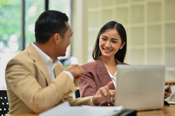 Happy business team working together on investment and marketing projects at modern office