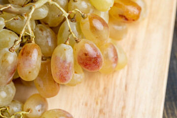 Green grapes unwashed lying on the board
