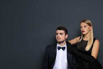 A woman and a man in Halloween costumes on a dark background