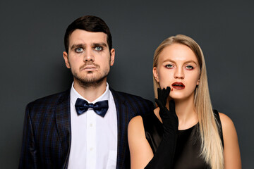 A woman and a man in Halloween costumes on a dark background
