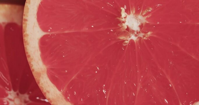 Micro video of close up of red grapefruit slices with copy space