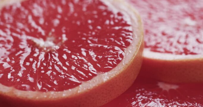 Micro video of close up of red grapefruit slices with copy space