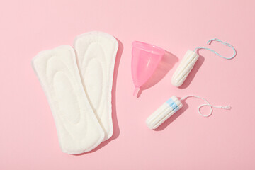 Menstrual feminine hygiene products on a pink background