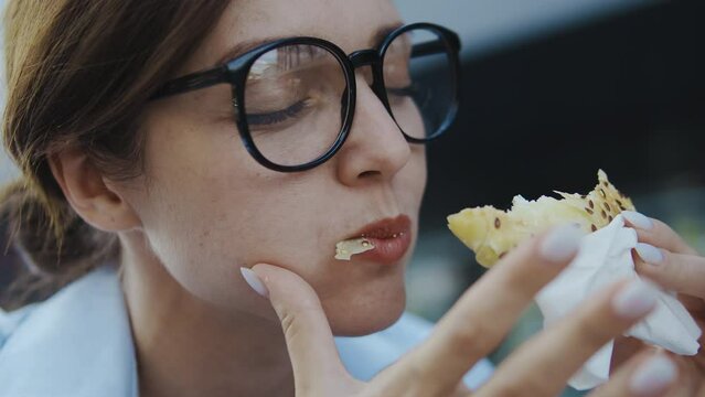 Extremely hungry woman biting fresh fragrant bakery enjoying taste of baked bun