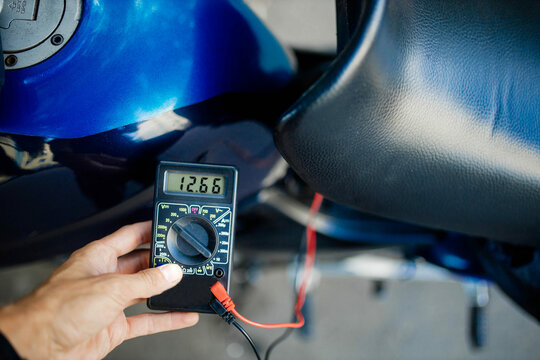 motorcycle battery voltage diagnostics with a multimeter. - Powered by Adobe