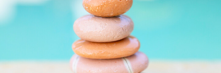 pyramid of stones by the sea at dawn, balanced zen stones, spa and relax concept, meditation