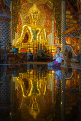 Pretty girl wearing beautiful traditional Thai dresses in Asian tradition Buddhism to make merit at Wat Sri Don Moon Temple in Chiang Mai, Thailand.