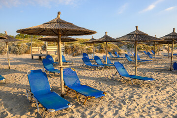 Fototapeta na wymiar Sunbeds with umbrella on sandy beach of Marmari. The Greek island of Kos